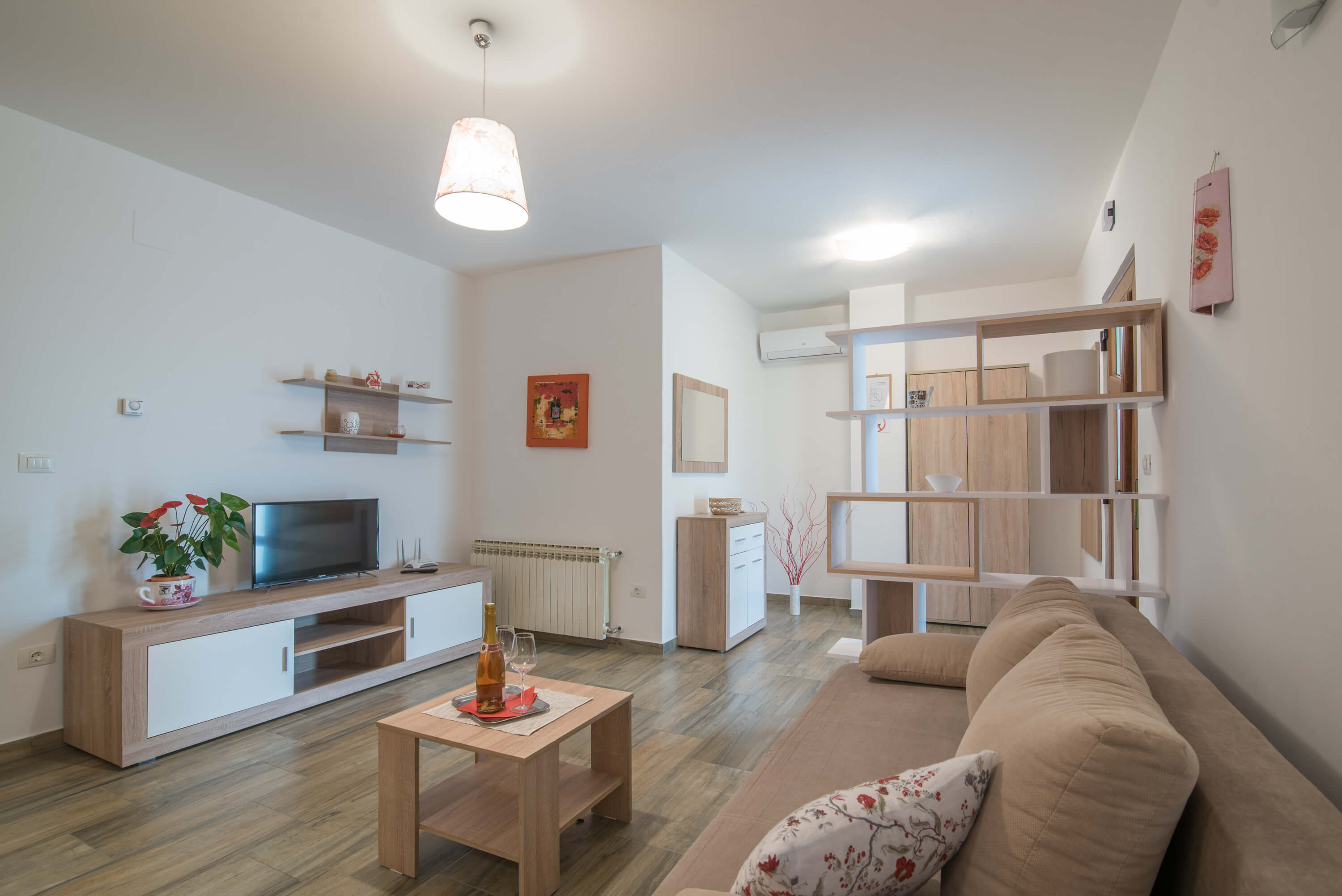 Beautiful colorful sunny garden, spacious parking space and a tiled access path. Colorful flowers filling the garden. A covered terrace and pergola in front of the apartment's entrance . Olive grove and nature in the background.